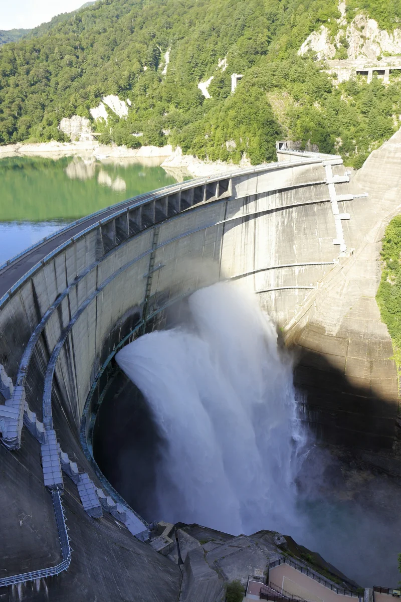 A large dam releasing water into a river gorge